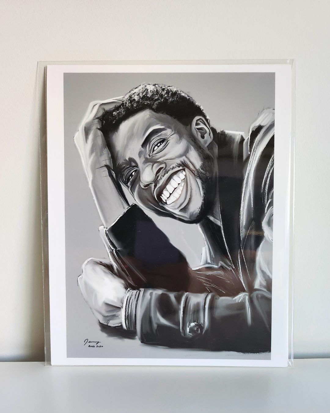 Chadwick Boseman portrait print by Full Art Alchemist, sleeved and standing upright against white wall