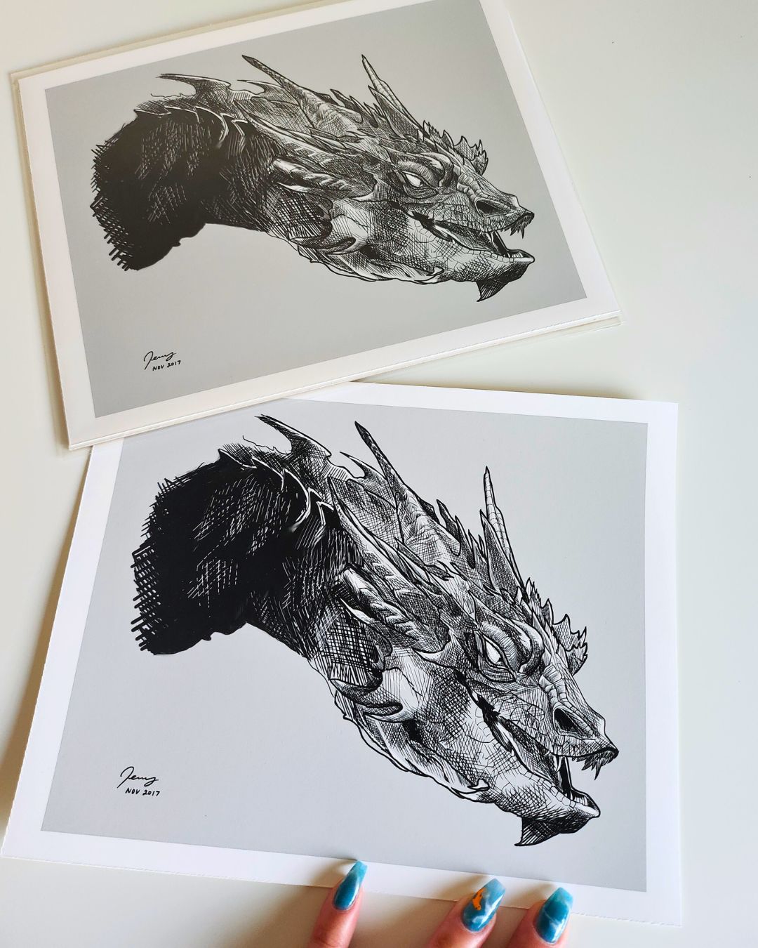 Fantasy dragon art print photographed at an angle — archival sleeve with soft shadows and natural light